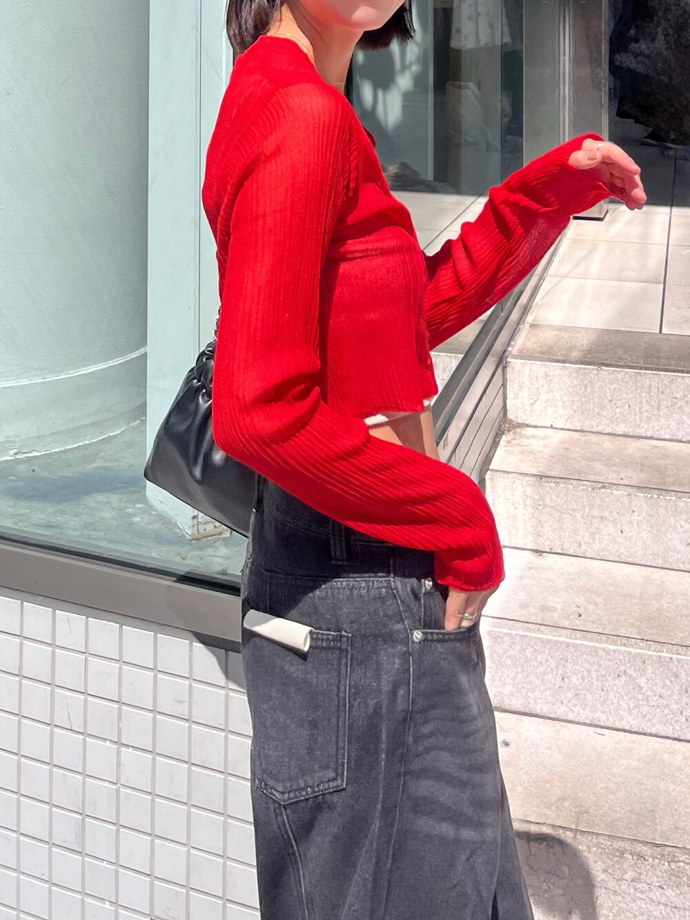 レッド系のカーディガン/ボレロ、ブルー系のデニムパンツを着用したレディースの秋コーディネートの2枚目の写真