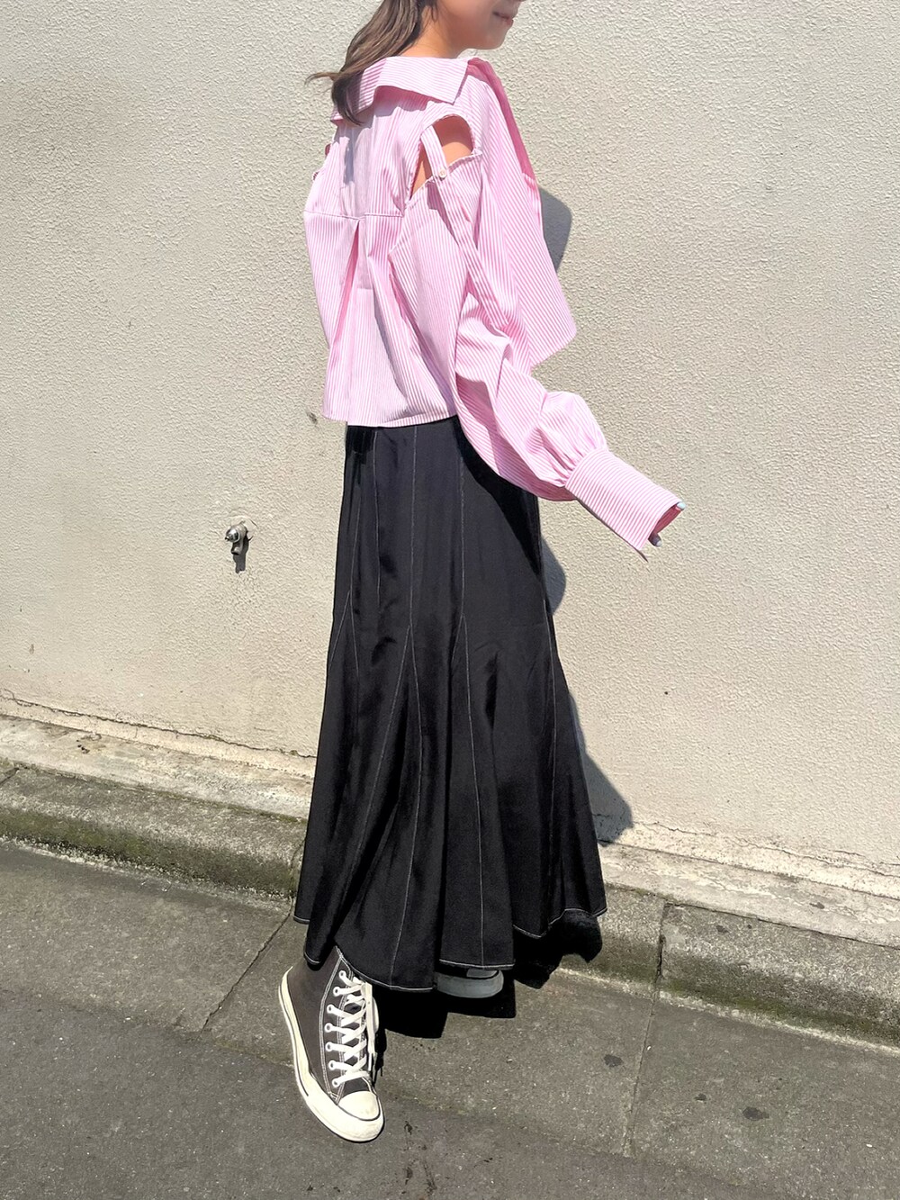 ピンク系のシャツ/ブラウス、ブラック系のスカート、ブラック系のスニーカーを着用したレディースの夏コーディネートの2枚目の写真