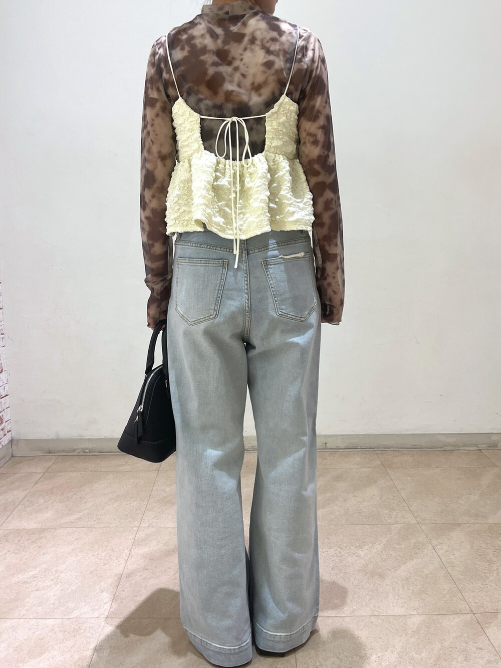 グレー系のテーラードジャケット、ブラック系のシャツ/ブラウス、ホワイト系のデニムパンツを着用したレディースの春コーディネートの3枚目の写真