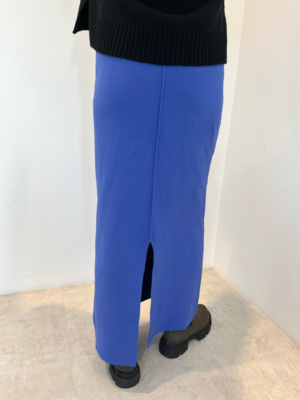 ホワイト系のTシャツ/カットソー、ブラック系のニット/セーター、ブルー系のスカートを着用したレディースの秋コーディネートの5枚目の写真