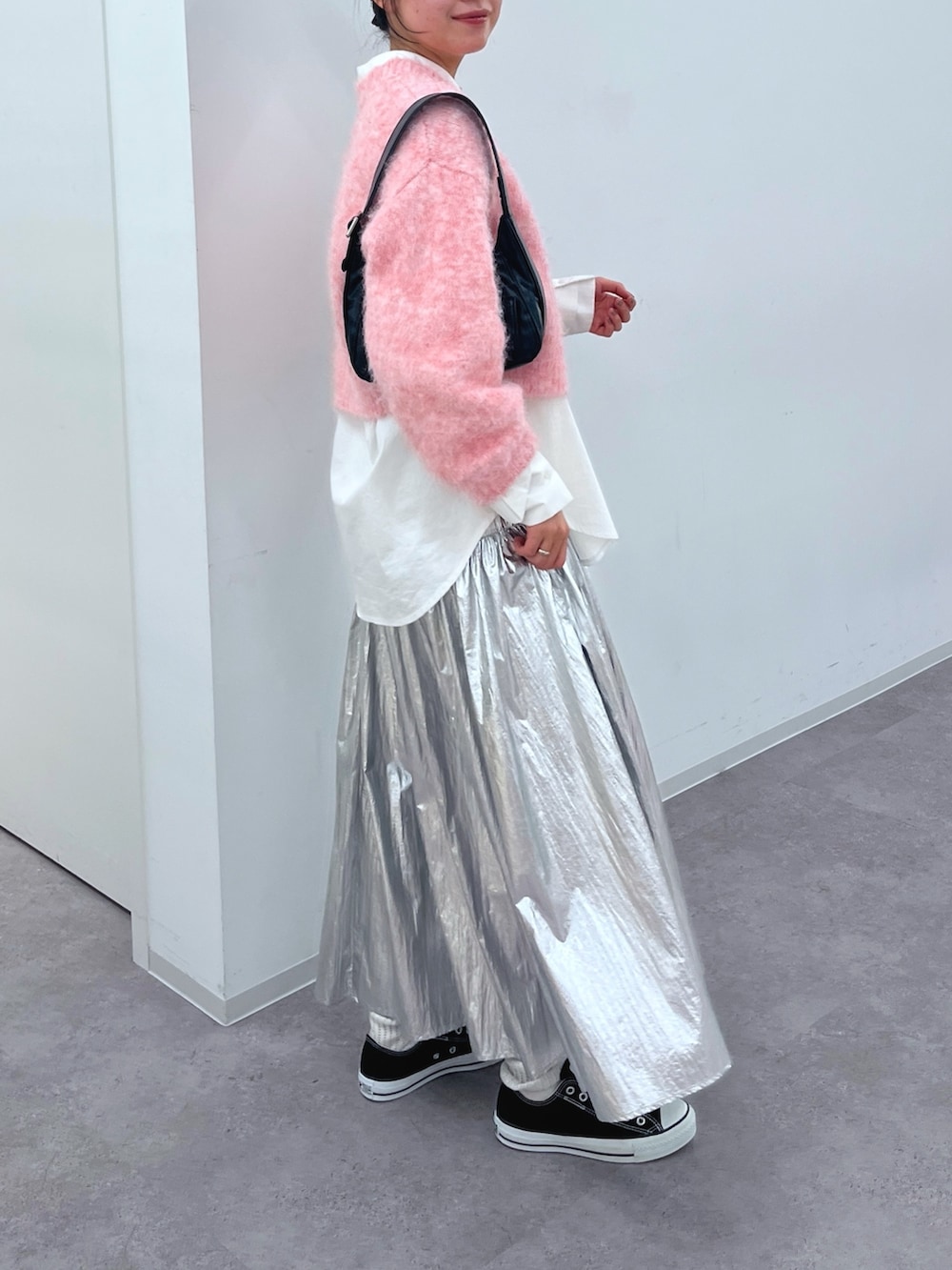 ピンク系のニット/セーター、ホワイト系のシャツ/ブラウス、シルバー系のスカートを着用したレディースの冬コーディネートの3枚目の写真