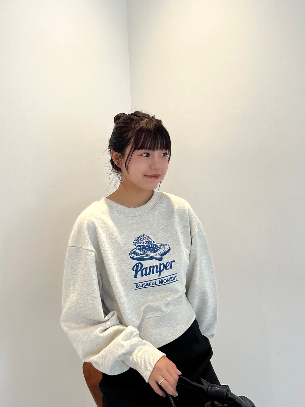 ホワイト系のTシャツ/カットソー、ブラック系のスカート、ホワイト系のスニーカーを着用したレディースの秋コーディネートの3枚目の写真