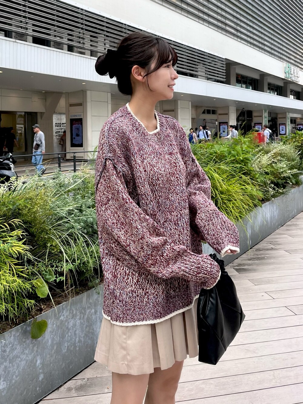 レッド系のニット/セーター、ベージュ系のスカートを着用したレディースの秋コーディネートの2枚目の写真