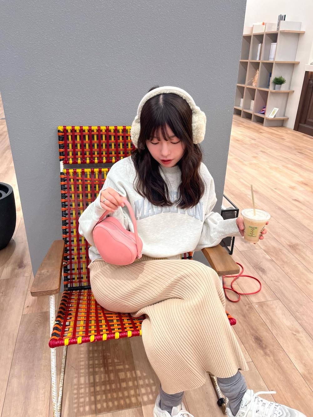 ホワイト系のスウェット、ゴールド系のスカート、ピンク系のショルダーバッグを着用したレディースの冬コーディネートの2枚目の写真