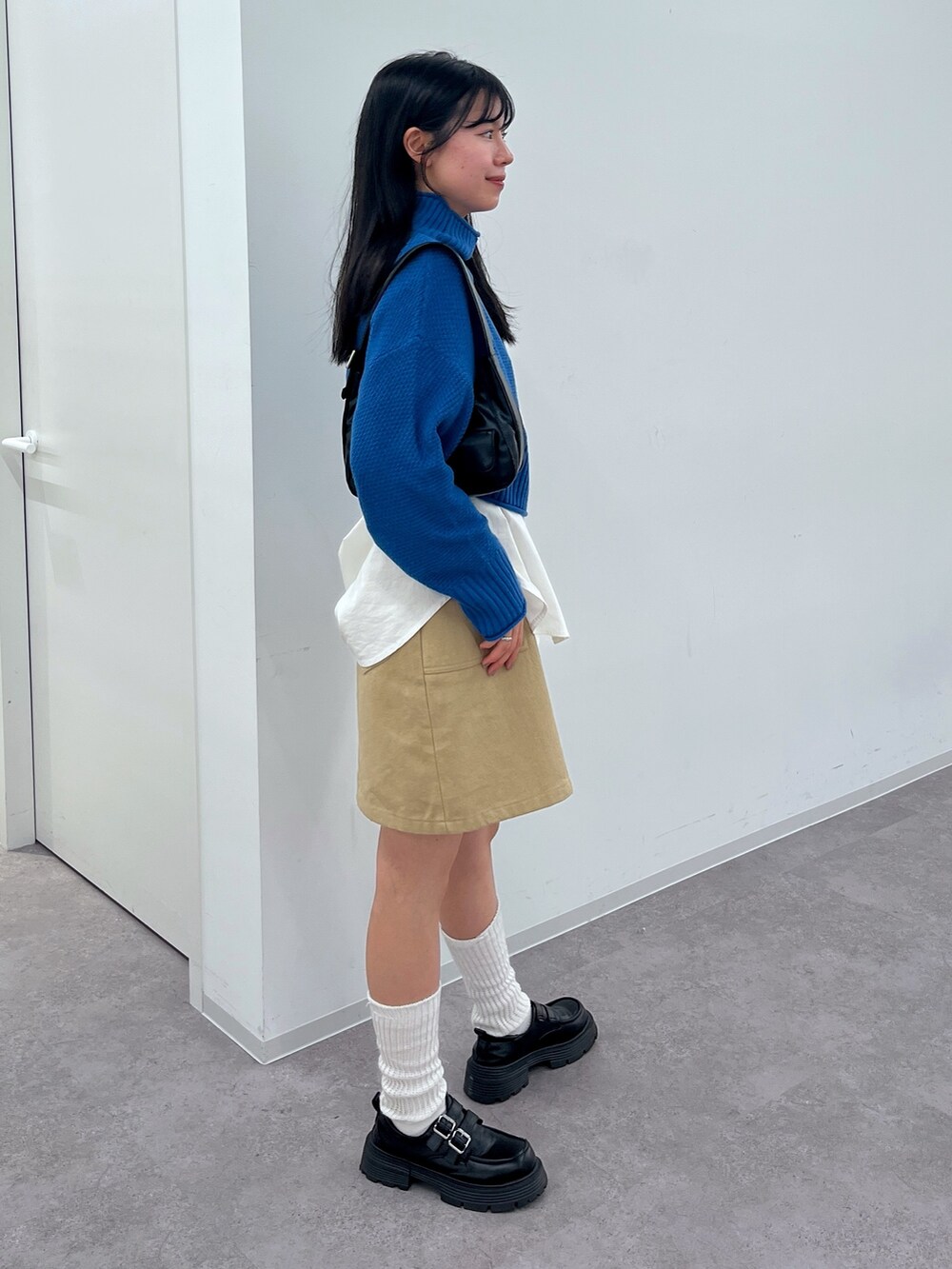 ブルー系のニット/セーター、ホワイト系のシャツ/ブラウスを着用したレディースの冬コーディネートの2枚目の写真