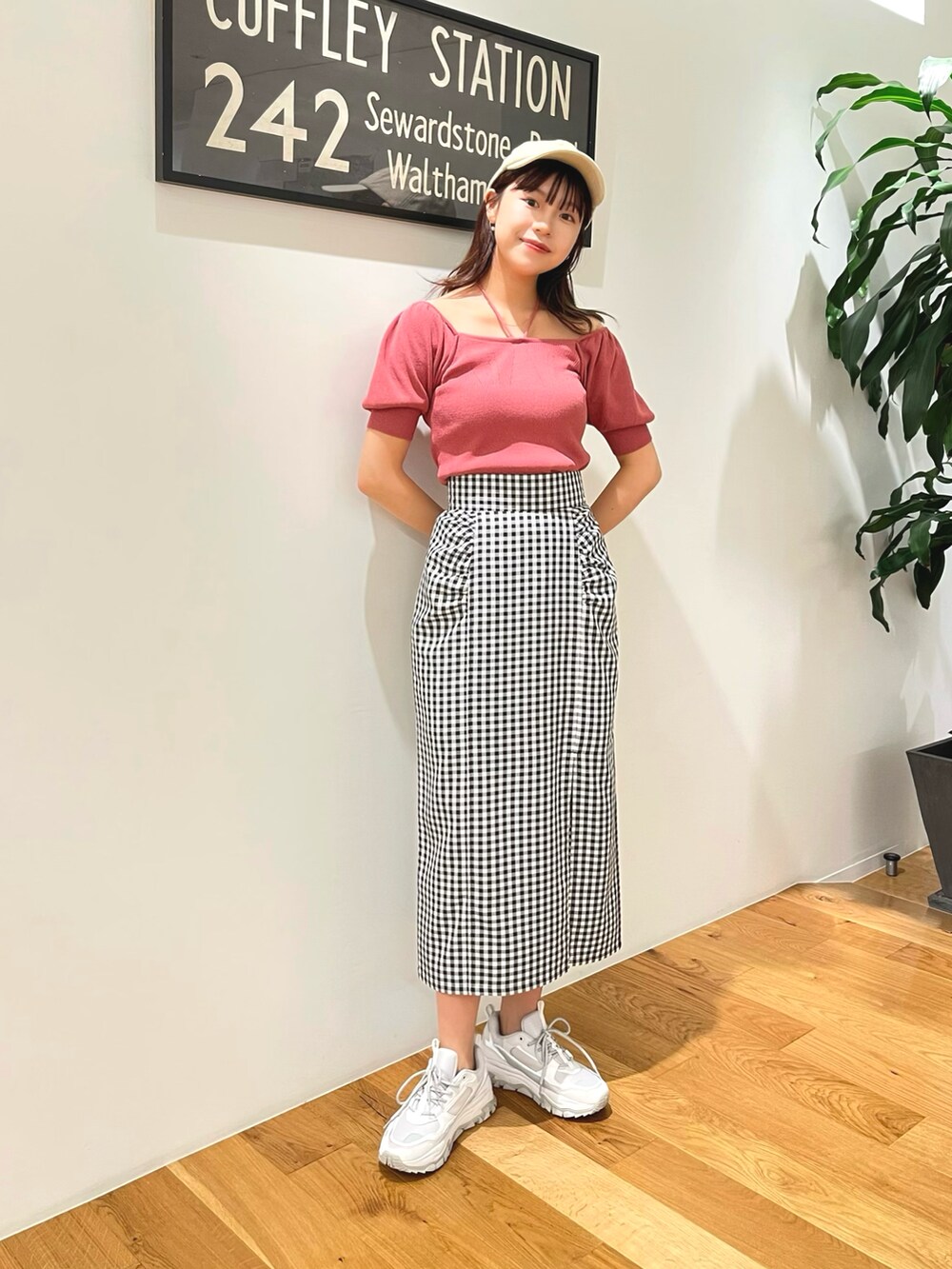 ピンク系のニット/セーター、ホワイト系のスカート、ベージュ系のキャップを着用したレディースの夏コーディネートの3枚目の写真