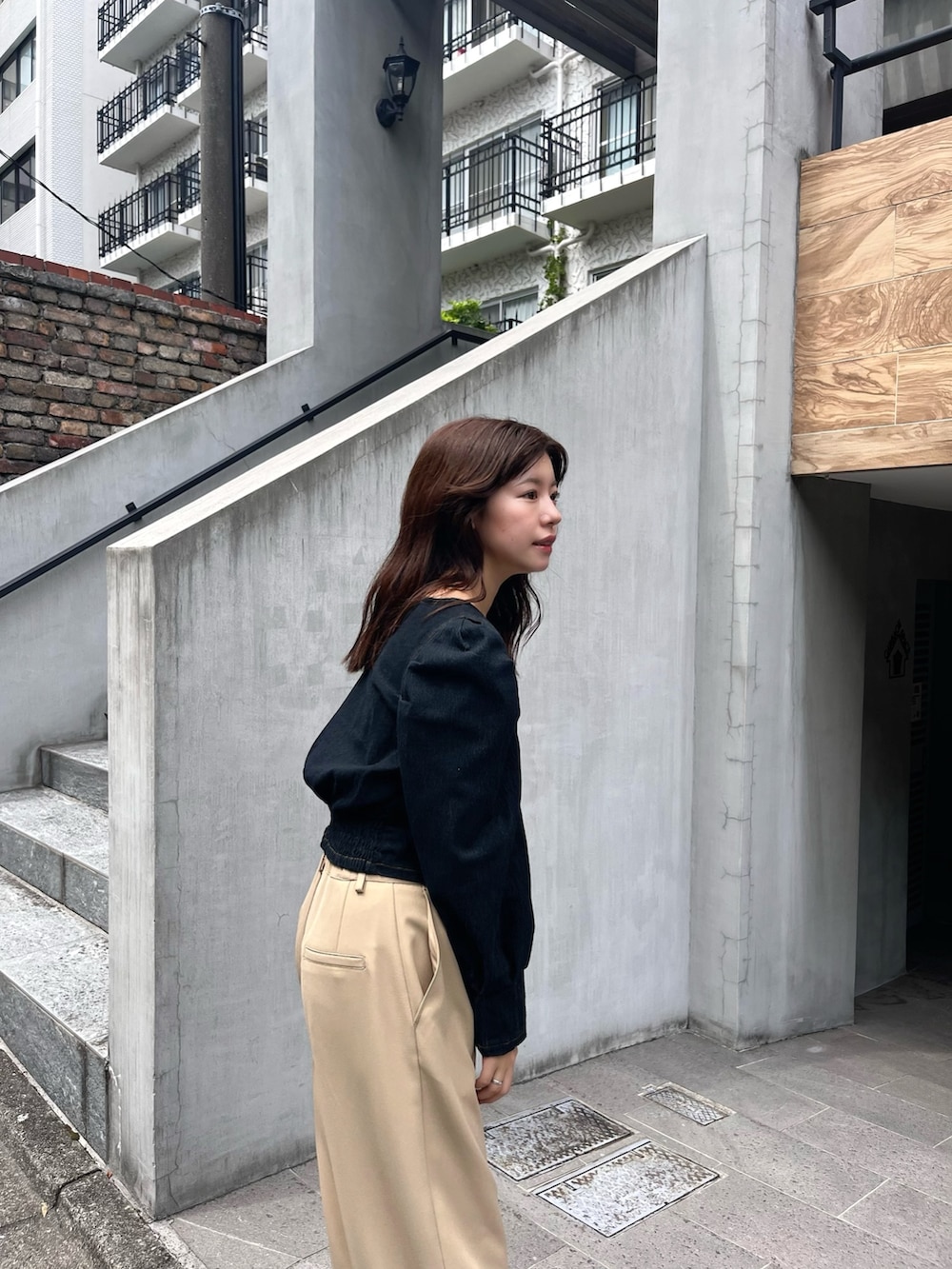 ブラック系のシャツ/ブラウス、ベージュ系のスラックス、グレー系のショルダーバッグを着用したレディースの夏コーディネートの2枚目の写真