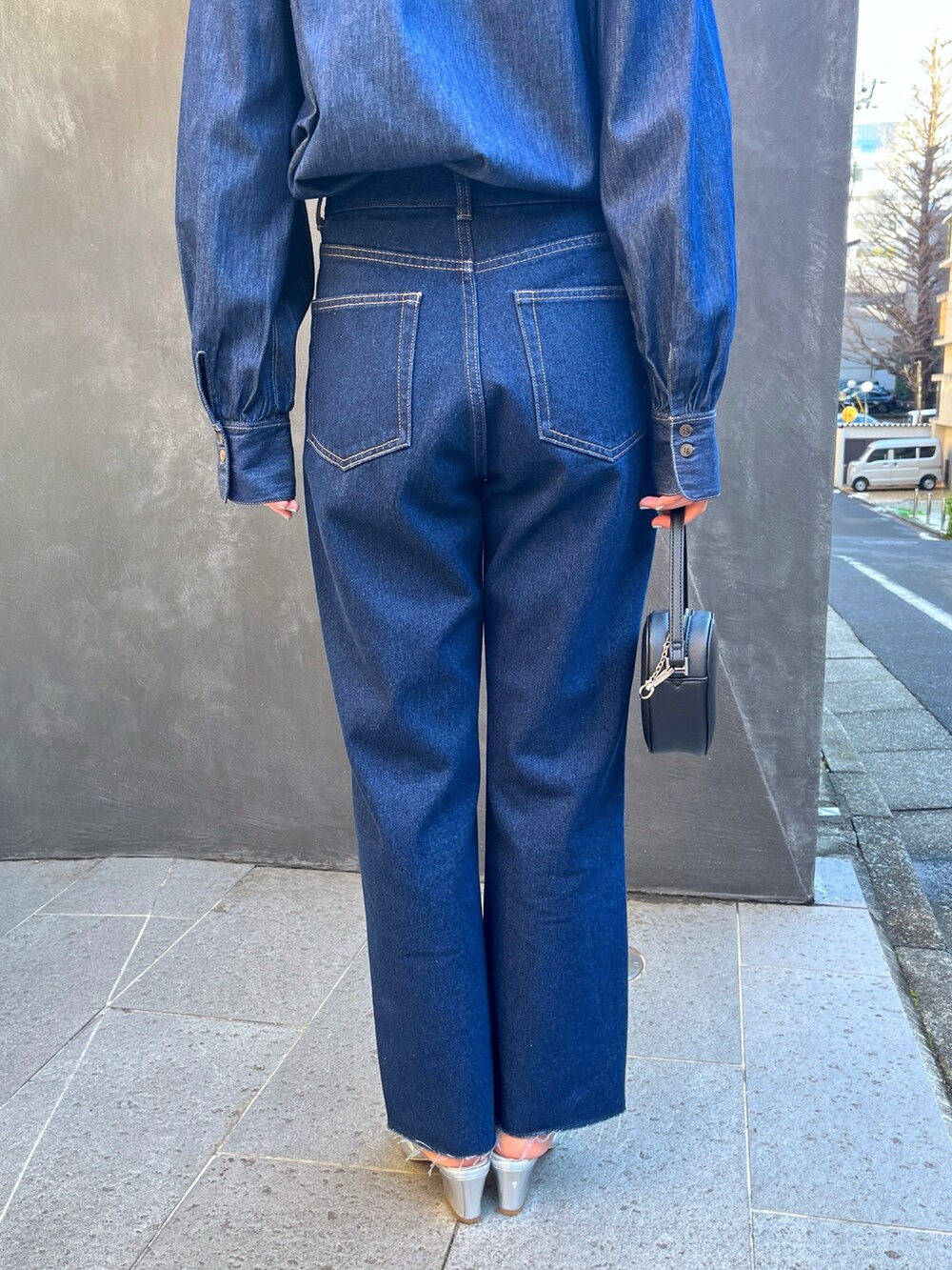 ブルー系のデニムパンツ、ブラック系のショルダーバッグを着用したレディースの春コーディネートの5枚目の写真