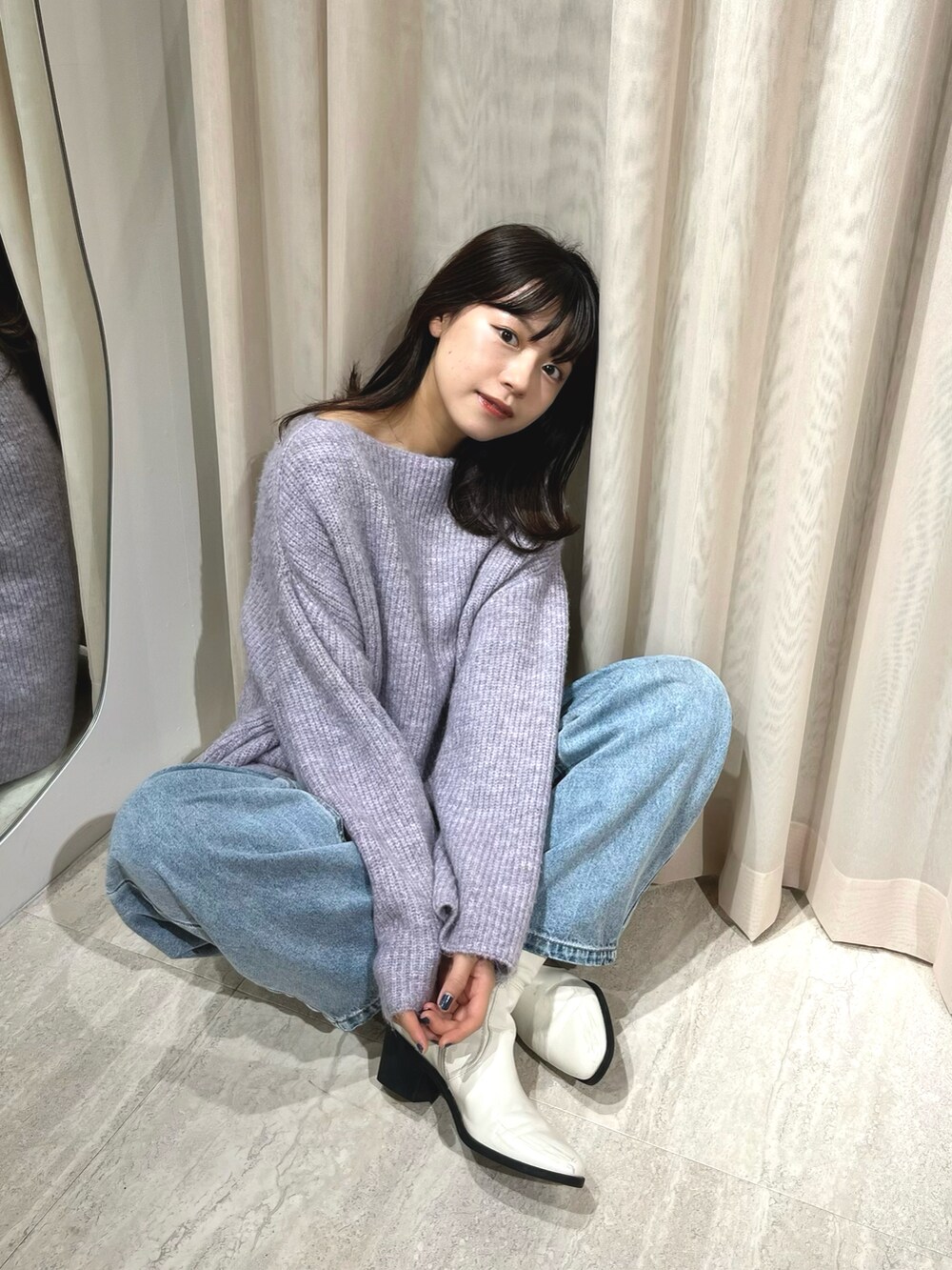 パープル系のニット/セーター、ブルー系のデニムパンツを着用したレディースの冬コーディネートの2枚目の写真