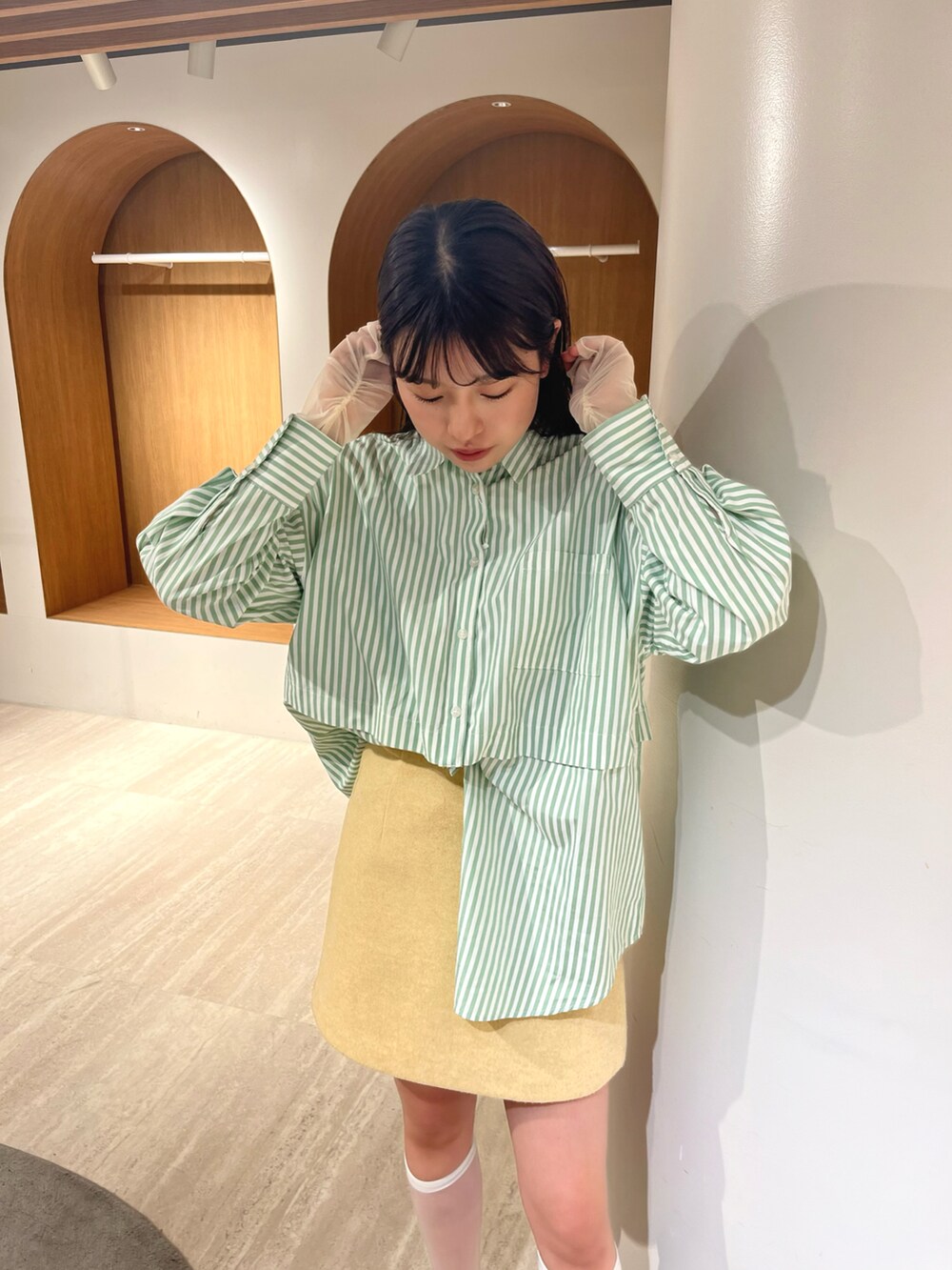 グリーン系のシャツ/ブラウス、イエロー系のスカート、ホワイト系のTシャツ/カットソーを着用したレディースの冬コーディネートの3枚目の写真