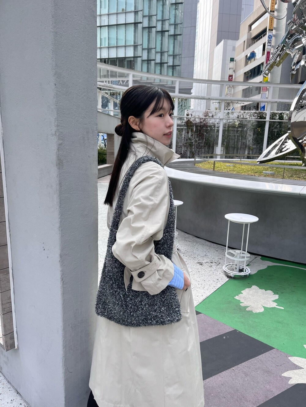 ベージュ系のトレンチコート、ホワイト系のスニーカーを着用したレディースの冬コーディネートの3枚目の写真