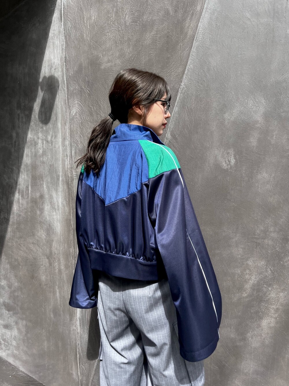 ブルー系のナイロンジャケット、グレー系のスラックスを着用したレディースの秋コーディネートの5枚目の写真