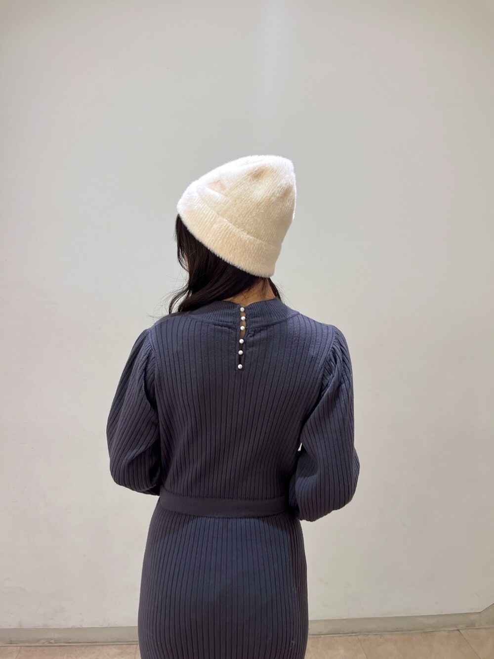 ブラック系のワンピース、ブラック系のブーツ、ブラック系のトートバッグを着用したレディースの冬コーディネートの4枚目の写真