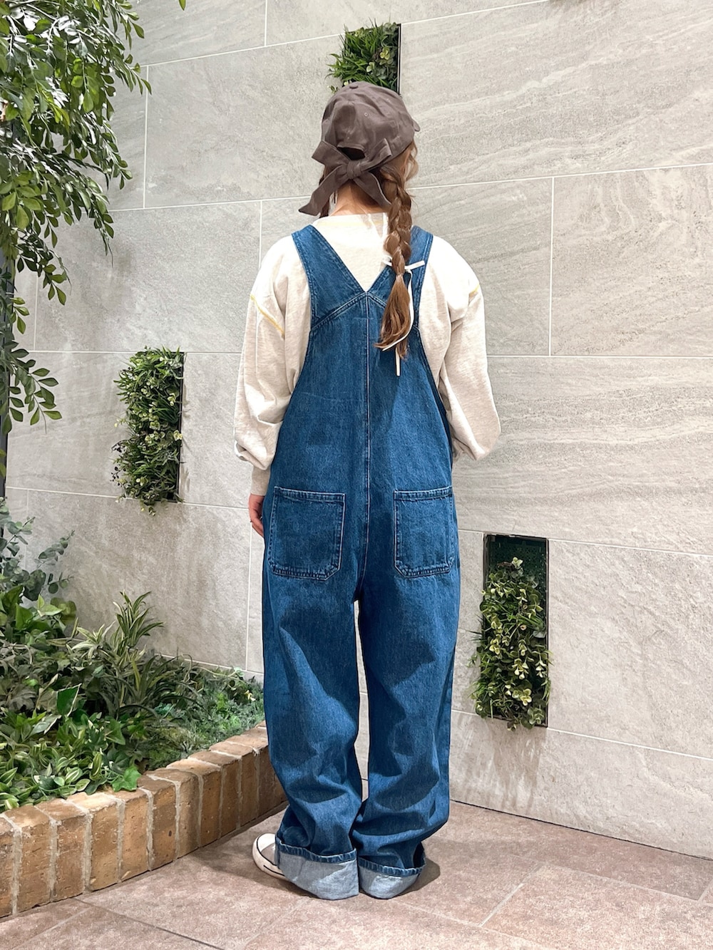 ブルー系のオールインワン・サロペット、グレー系のTシャツ/カットソー、ブラウン系のハットを着用したレディースの夏コーディネートの2枚目の写真