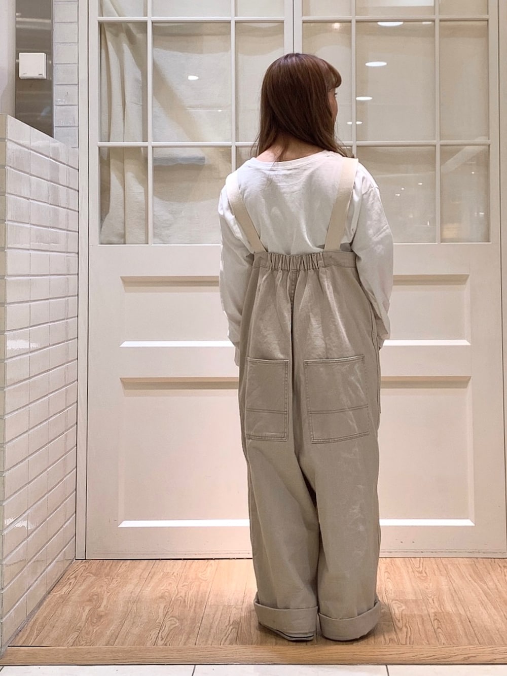 ベージュ系のサロペット/オーバーオール、ブルー系のTシャツ/カットソーを着用したレディースの春コーディネートの3枚目の写真