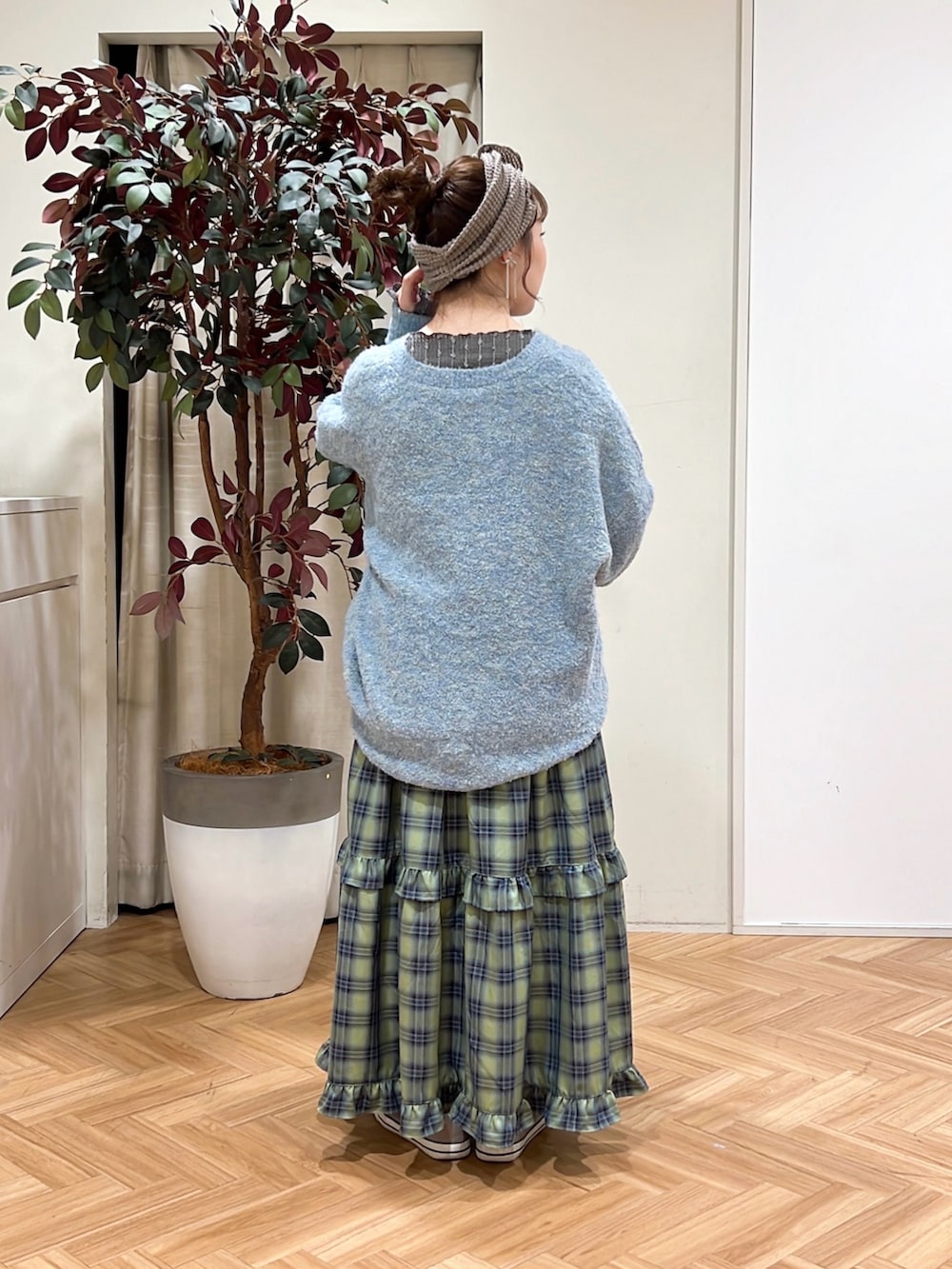 グリーン系のスカート、ブルー系のワンピース、グレー系のTシャツ/カットソーを着用したレディースの冬コーディネートの2枚目の写真