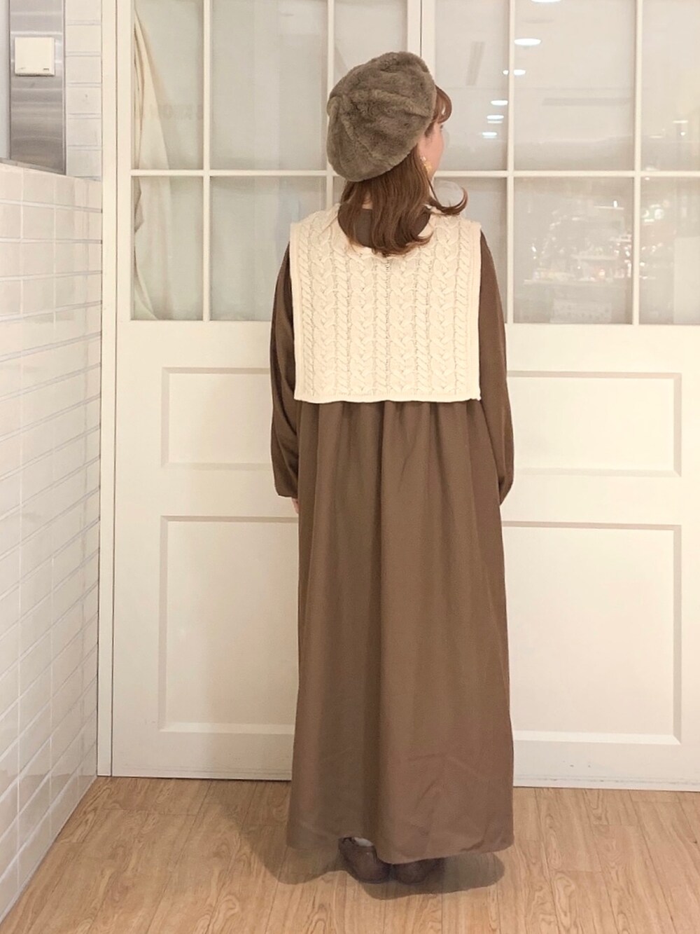 ブラウン系のワンピース、ホワイト系のベスト、ブラウン系のショルダーバッグを着用したレディースの秋コーディネートの4枚目の写真