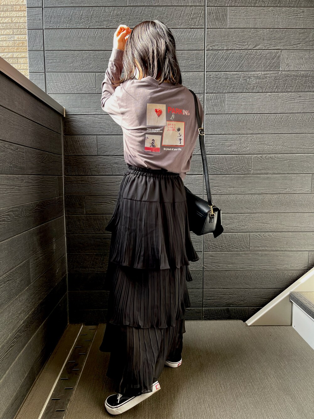 ブラック系のスカート、ブラック系のスニーカー、グレー系のTシャツ/カットソーを着用したレディースの秋コーディネートの2枚目の写真