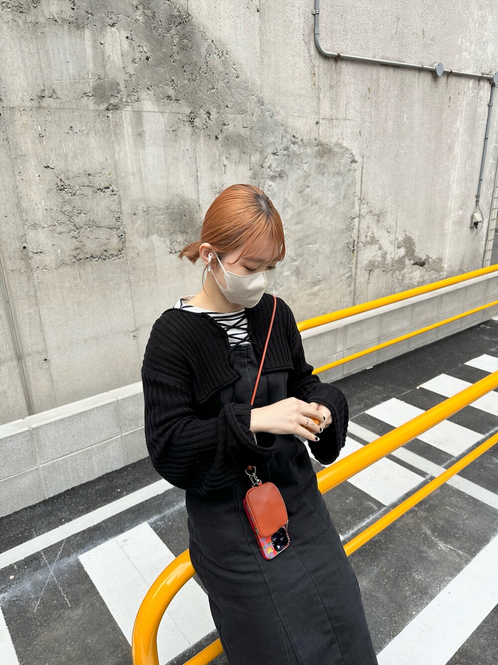 ベージュ系のモカシン/デッキシューズ、ブラック系のジャンパースカート、ホワイト系のシャツ/ブラウスを着用したレディースの春コーディネートの4枚目の写真