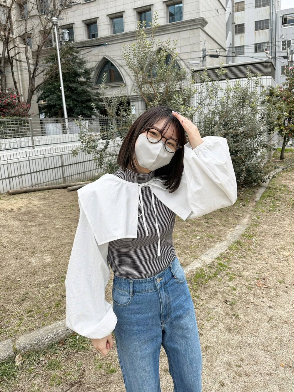 ブラック系のブーツ、ブルー系のデニムパンツ、ホワイト系のシャツ/ブラウスを着用したレディースの冬コーディネートの2枚目の写真