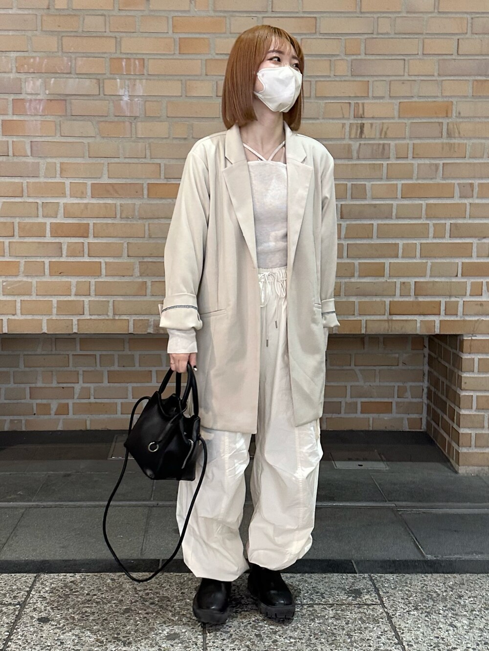 ホワイト系のカーゴパンツ、ブラック系のブーツ、ホワイト系のニット/セーターを着用したレディースの春コーディネートの3枚目の写真