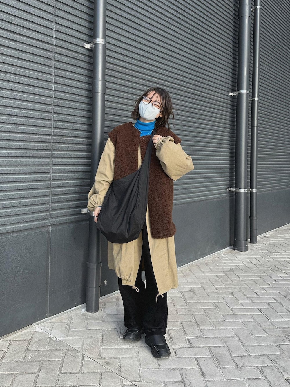 ブラック系のスニーカー、ベージュ系のミリタリージャケット、ホワイト系のベストを着用したレディースの冬コーディネートの3枚目の写真