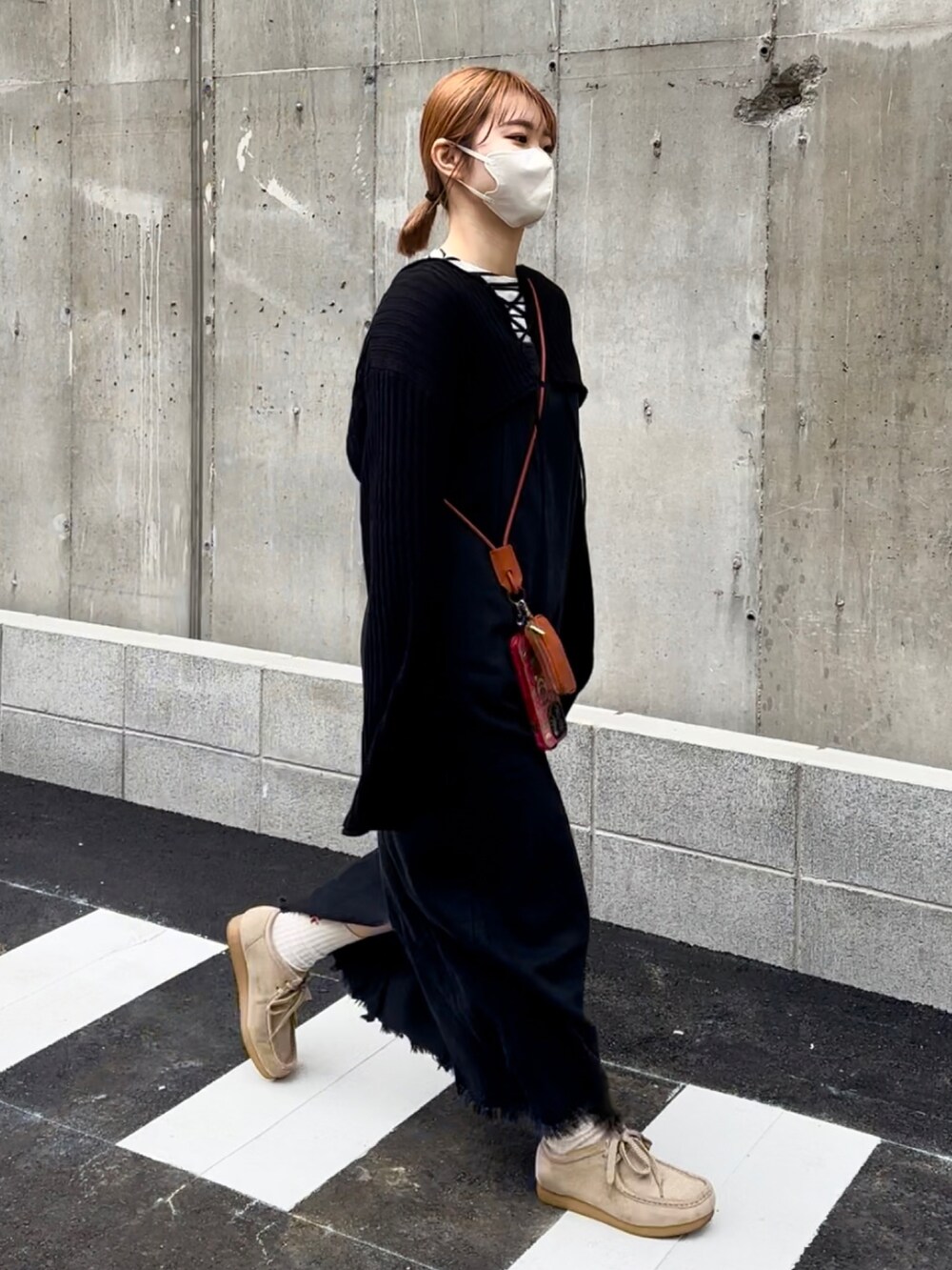 ベージュ系のモカシン/デッキシューズ、ブラック系のジャンパースカート、ホワイト系のシャツ/ブラウスを着用したレディースの春コーディネートの5枚目の写真