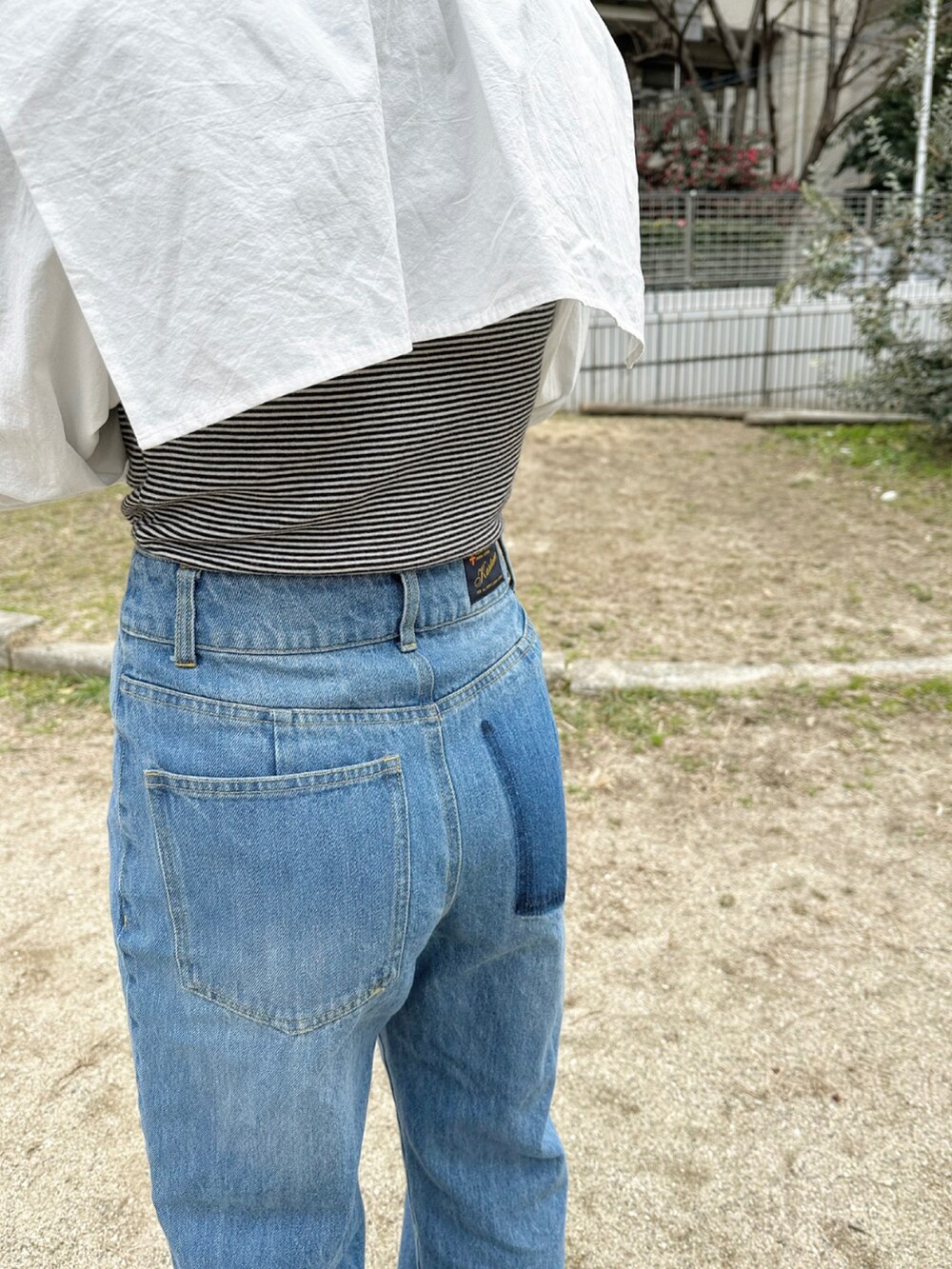 ブラック系のブーツ、ブルー系のデニムパンツ、ホワイト系のシャツ/ブラウスを着用したレディースの冬コーディネートの5枚目の写真