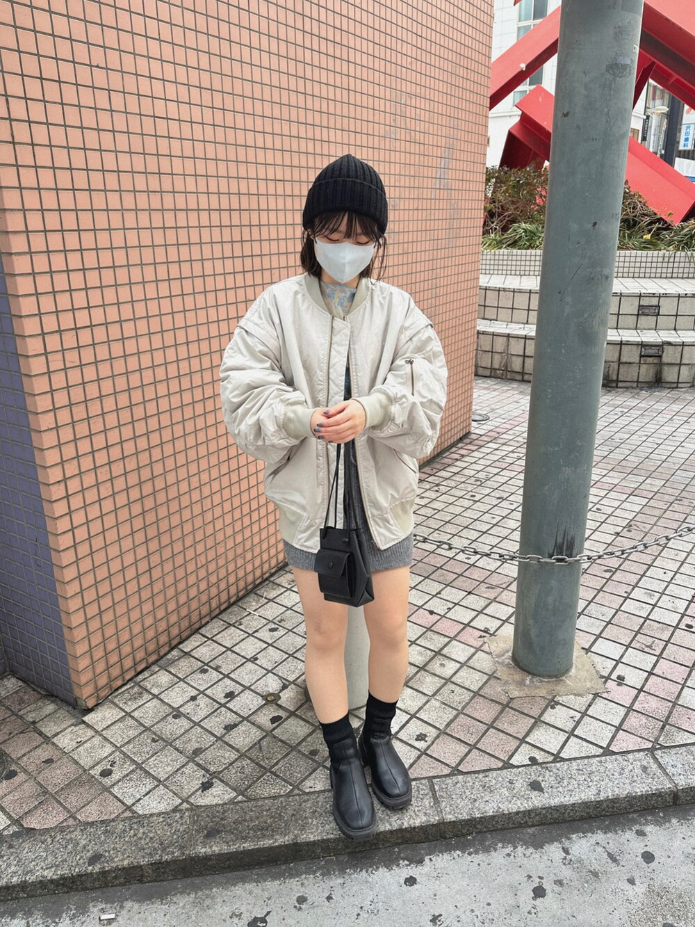 ブルー系のTシャツ/カットソー、ホワイト系のブルゾン、グレー系のその他パンツを着用したレディースの冬コーディネートの3枚目の写真