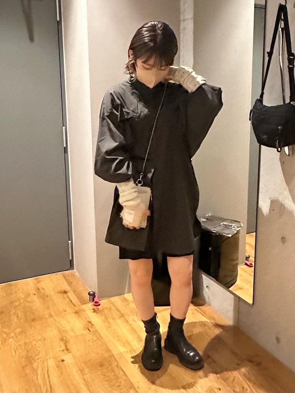 グレー系のワンピース、ブラック系のその他パンツ、ブラック系のブーツを着用したレディースの冬コーディネートの2枚目の写真