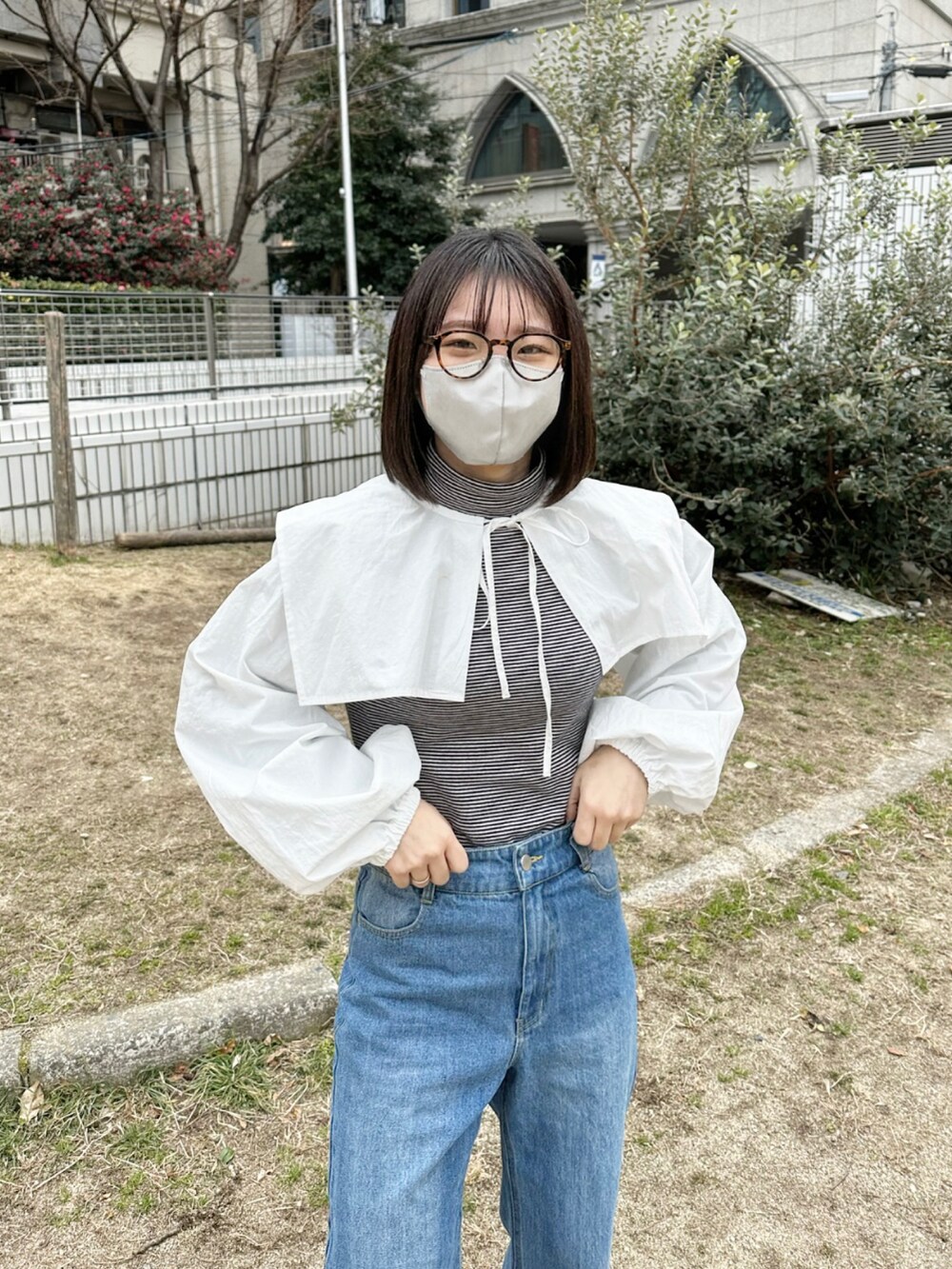 ブラック系のブーツ、ブルー系のデニムパンツ、ホワイト系のシャツ/ブラウスを着用したレディースの冬コーディネートの3枚目の写真