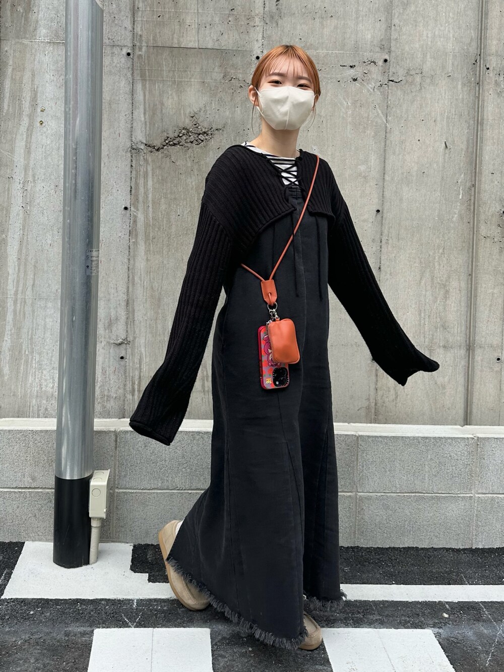 ベージュ系のモカシン/デッキシューズ、ブラック系のジャンパースカート、ホワイト系のシャツ/ブラウスを着用したレディースの春コーディネートの2枚目の写真