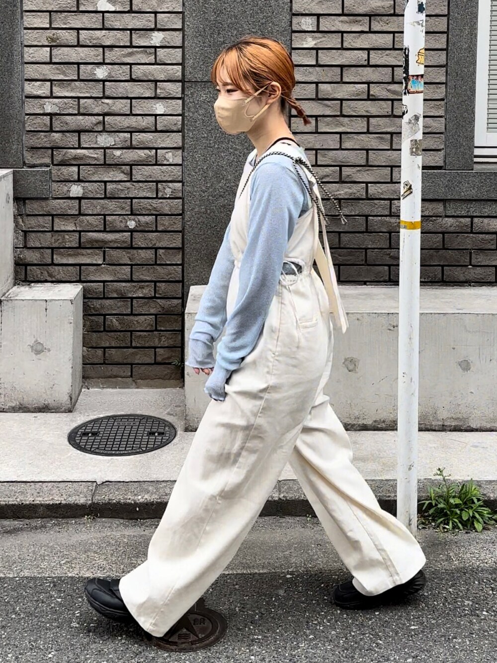 ブラック系のスニーカー、ホワイト系のサロペット/オーバーオール、ブルー系のTシャツ/カットソーを着用したレディースの春コーディネートの5枚目の写真