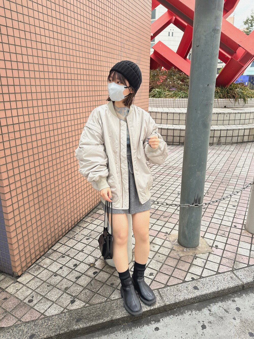 ブルー系のTシャツ/カットソー、ホワイト系のブルゾン、グレー系のその他パンツを着用したレディースの冬コーディネートの2枚目の写真