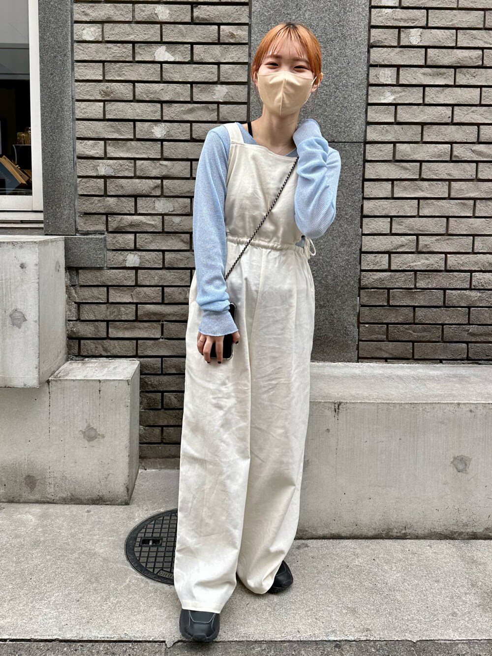 ブラック系のスニーカー、ホワイト系のサロペット/オーバーオール、ブルー系のTシャツ/カットソーを着用したレディースの春コーディネートの4枚目の写真