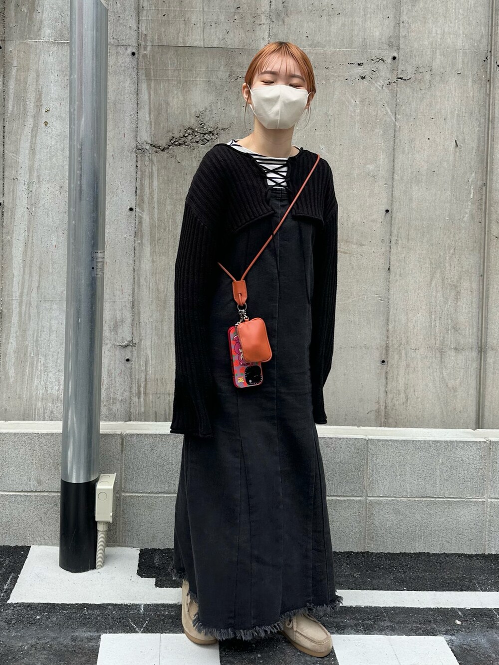 ベージュ系のモカシン/デッキシューズ、ブラック系のジャンパースカート、ホワイト系のシャツ/ブラウスを着用したレディースの春コーディネートの3枚目の写真