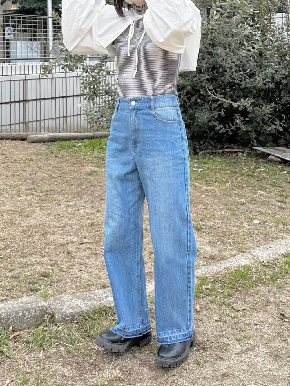 ブラック系のブーツ、ブルー系のデニムパンツ、ホワイト系のシャツ/ブラウスを着用したレディースの冬コーディネートの4枚目の写真