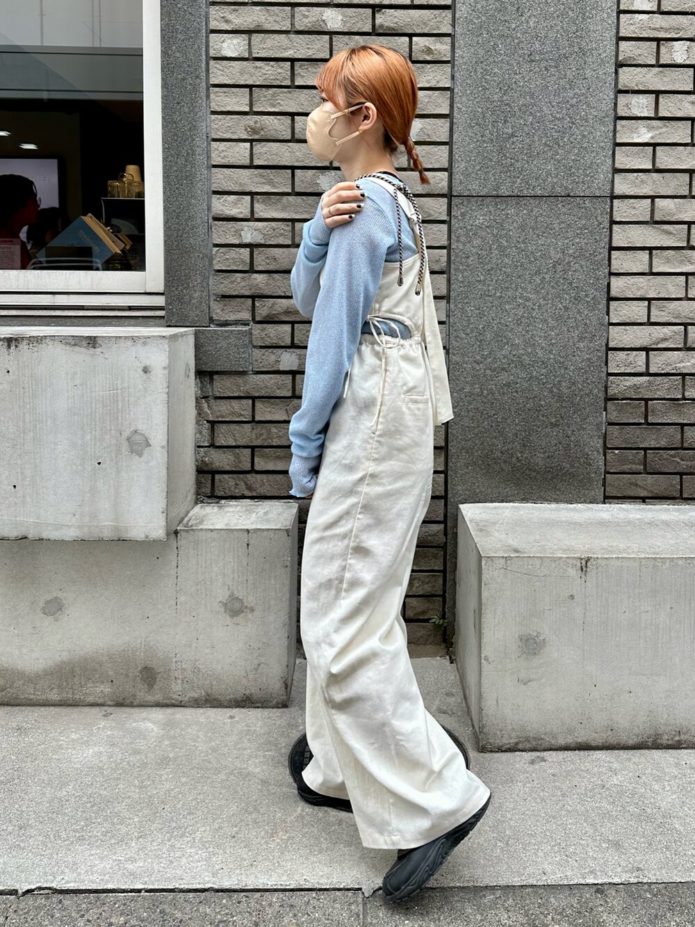 ブラック系のスニーカー、ホワイト系のサロペット/オーバーオール、ブルー系のTシャツ/カットソーを着用したレディースの春コーディネートの3枚目の写真