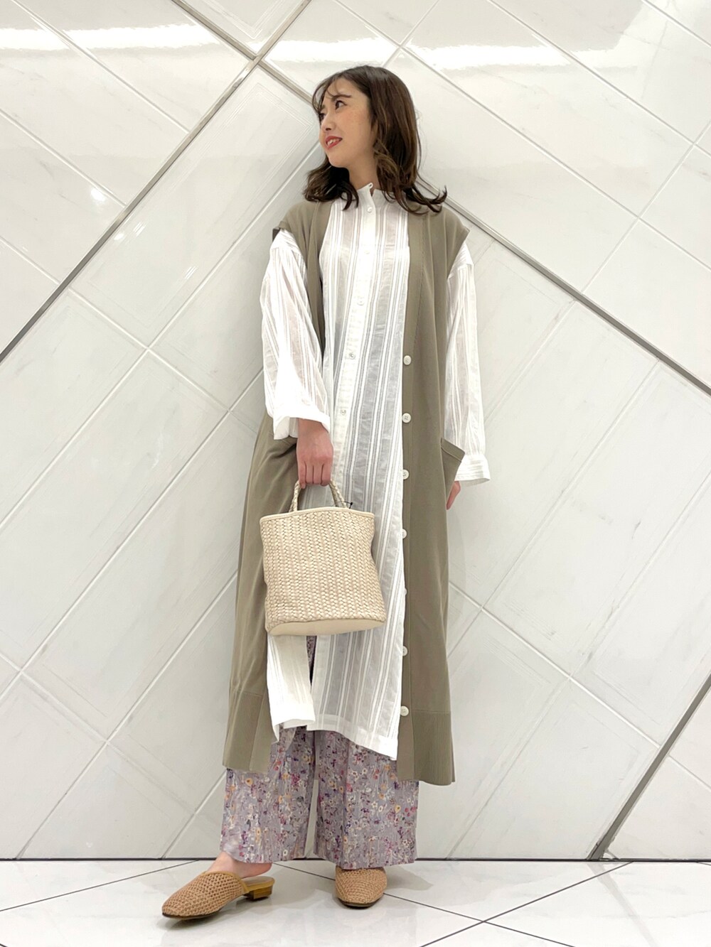 ベージュ系のニット/セーター、グレー系のその他パンツ、ホワイト系のワンピースを着用したレディースの春コーディネートの2枚目の写真