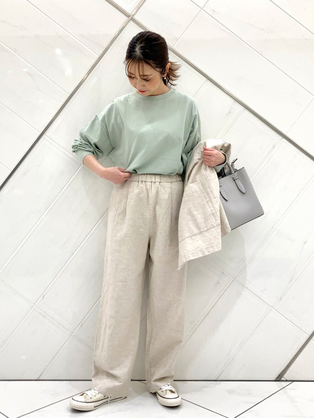 グリーン系のTシャツ/カットソー、ホワイト系のスニーカー、ベージュ系のノーカラージャケットを着用したレディースの春コーディネートの5枚目の写真