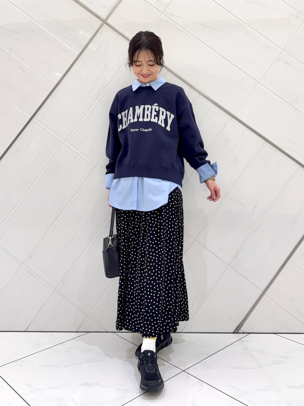 ブルー系のスウェット、ブラック系のスカート、ベージュ系のトレンチコートを着用したレディースの冬コーディネートの6枚目の写真