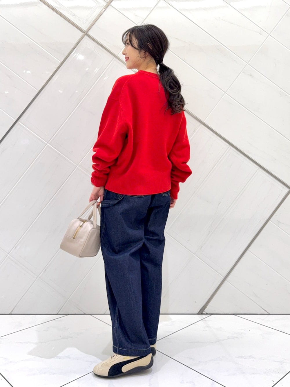 レッド系のニット/セーター、ホワイト系のTシャツ/カットソー、グレー系のボストンバッグを着用したレディースの秋コーディネートの8枚目の写真