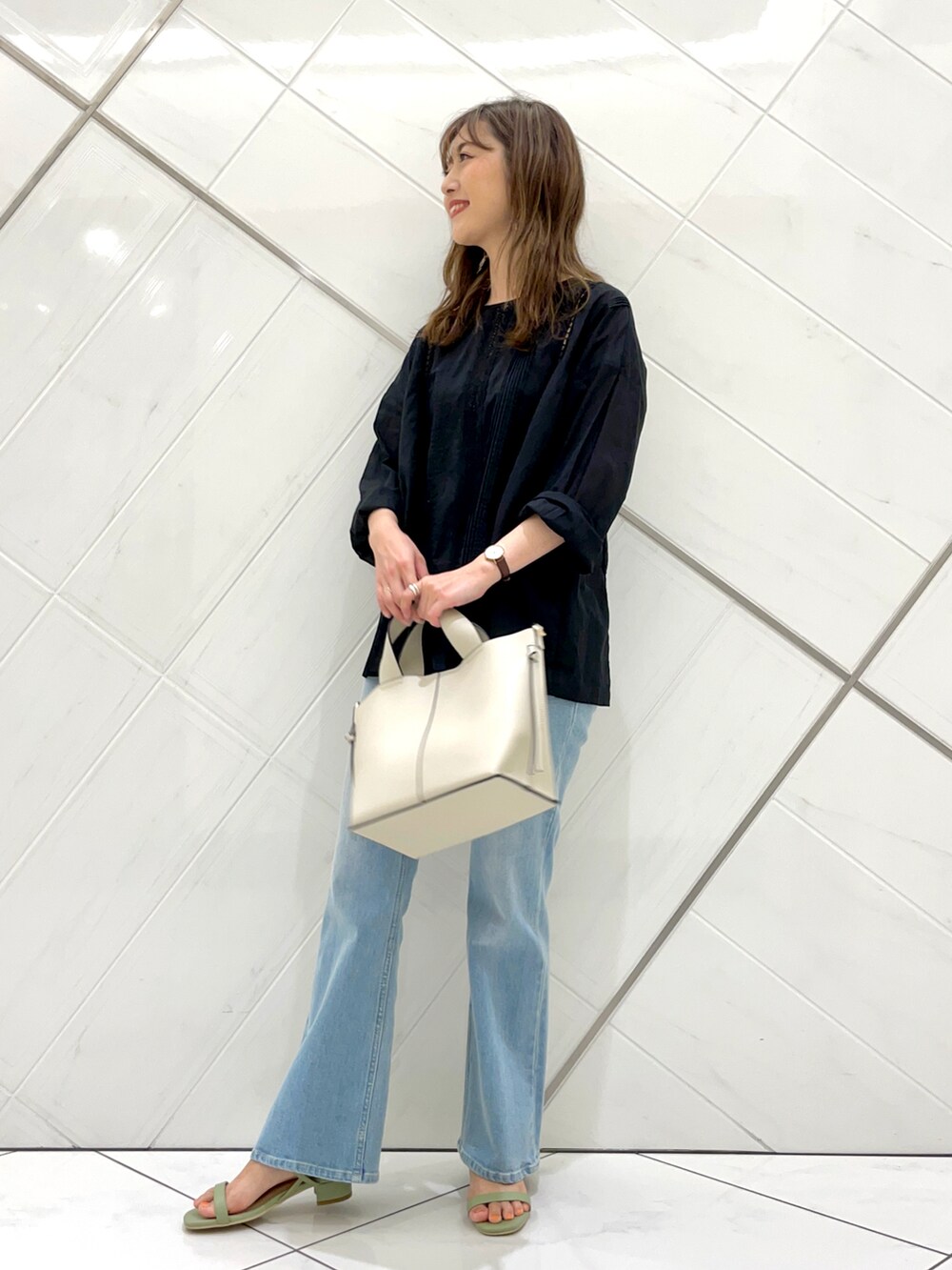 ブルー系のデニムパンツ、グリーン系のサンダル、ブラック系のTシャツ/カットソーを着用したレディースの夏コーディネートの3枚目の写真