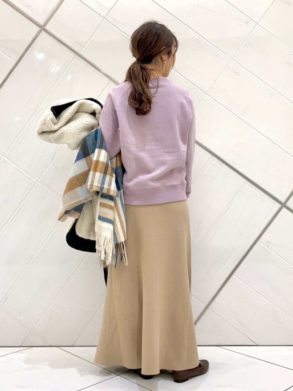 ブラウン系のローファー、ホワイト系のノーカラージャケット、ベージュ系のスカートを着用したレディースの冬コーディネートの5枚目の写真