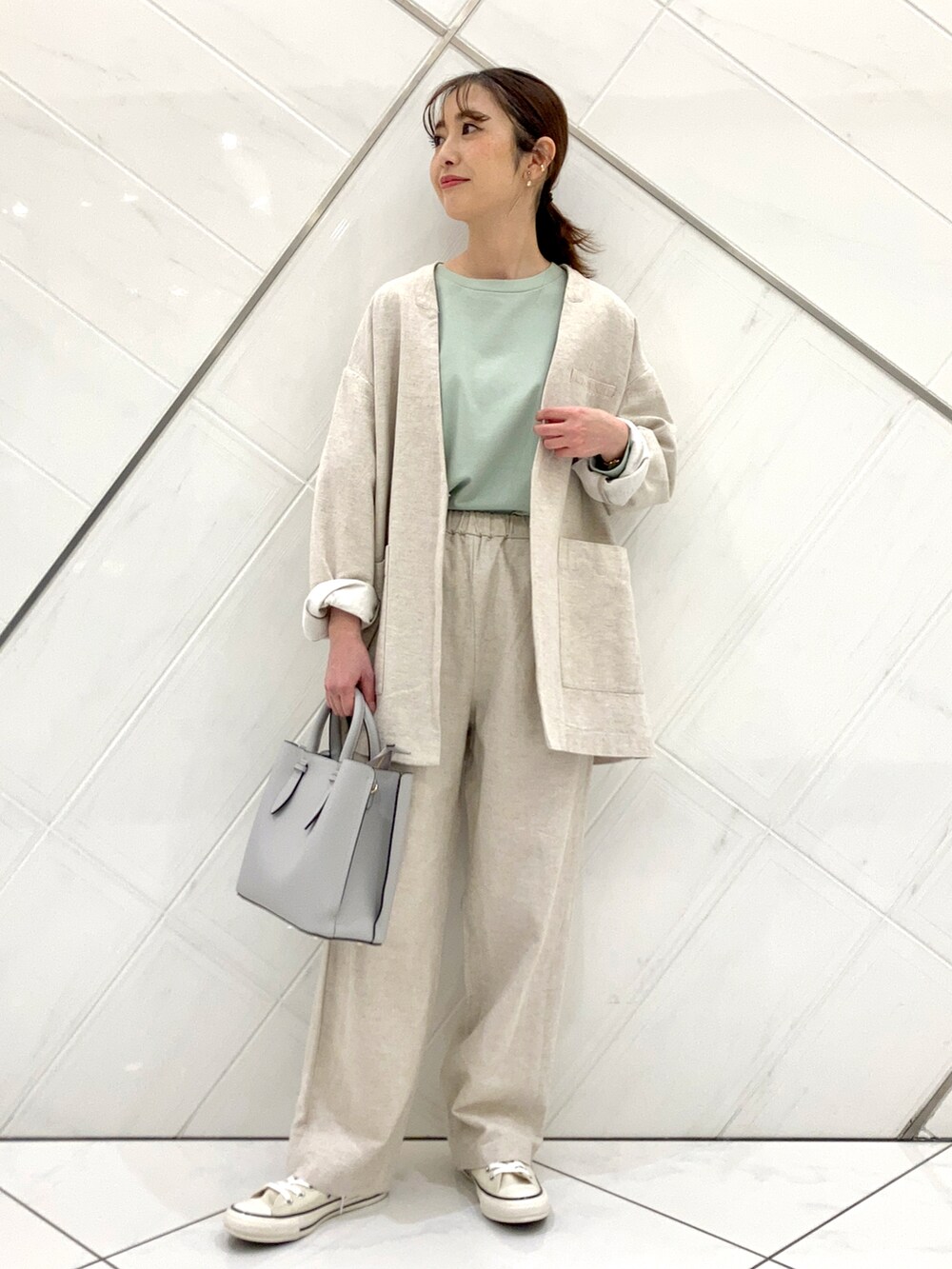 グリーン系のTシャツ/カットソー、ホワイト系のスニーカー、ベージュ系のノーカラージャケットを着用したレディースの春コーディネートの3枚目の写真