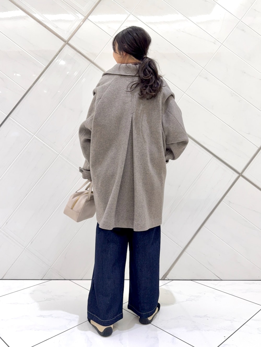 レッド系のニット/セーター、ホワイト系のTシャツ/カットソー、グレー系のボストンバッグを着用したレディースの秋コーディネートの4枚目の写真