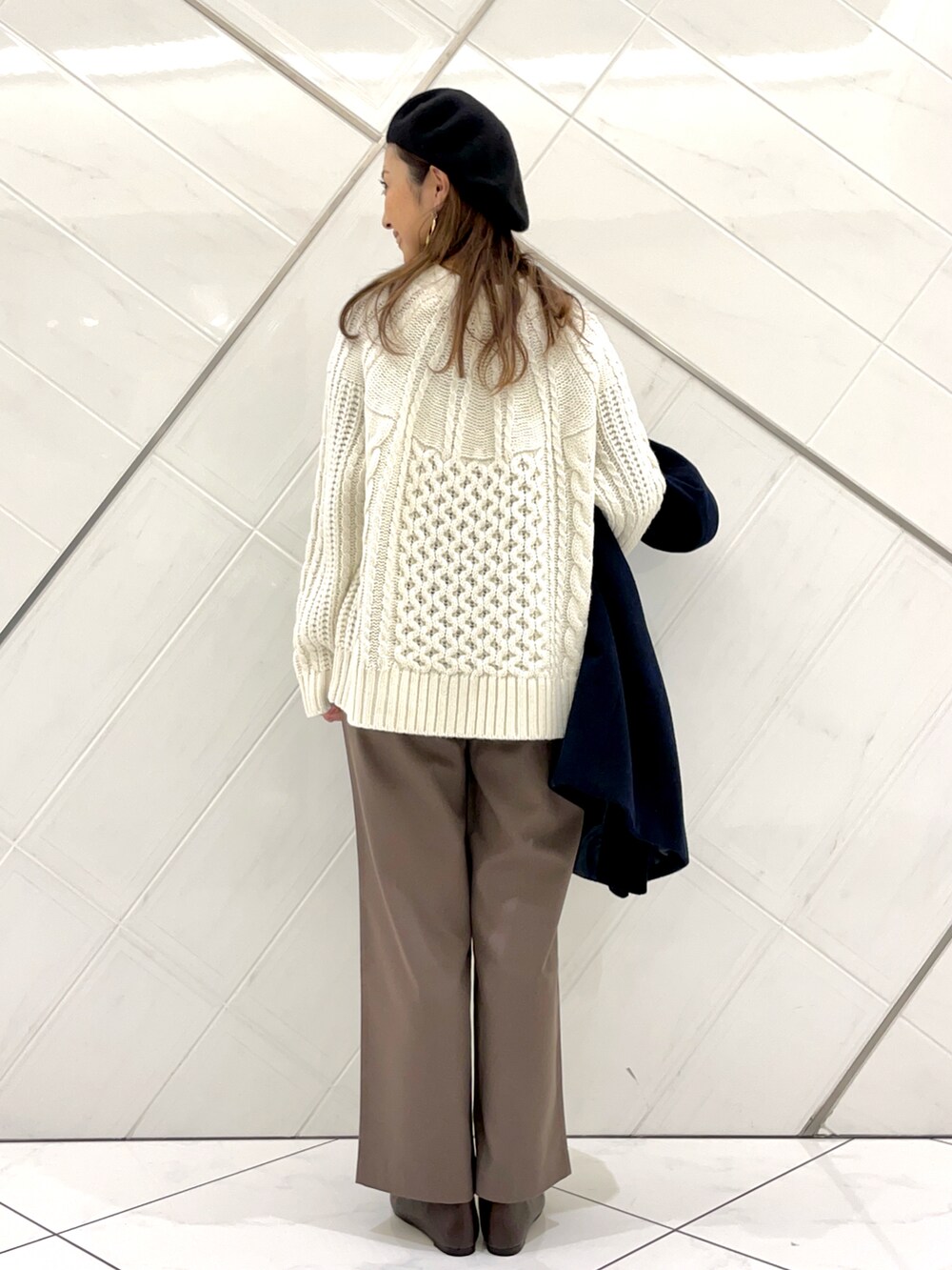 ブラウン系のパンプス、ブルー系のその他アウター、ホワイト系のニット/セーターを着用したレディースの冬コーディネートの5枚目の写真