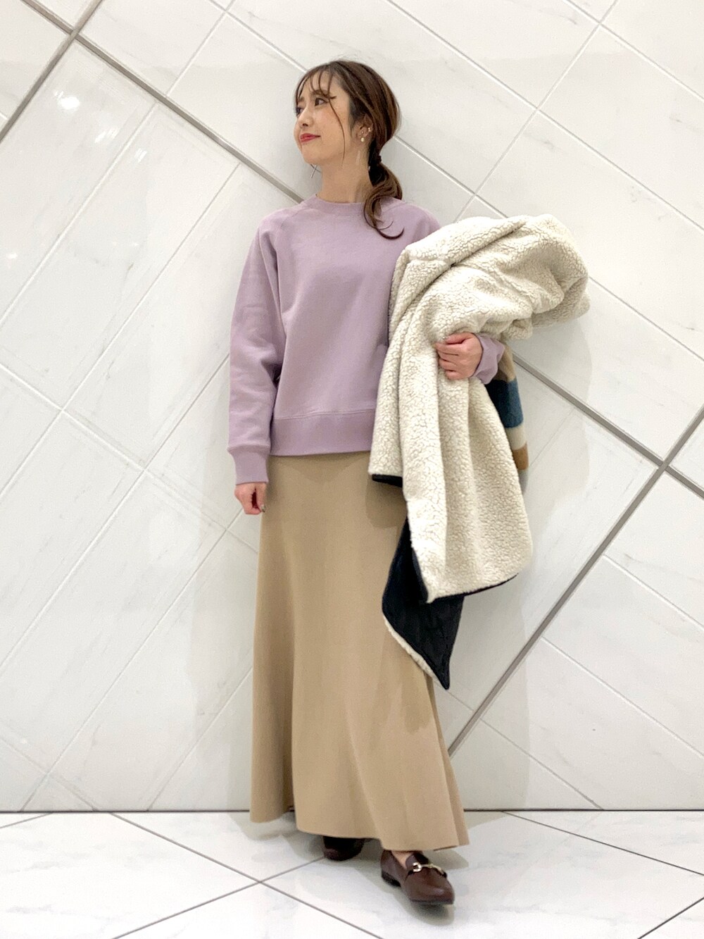 ブラウン系のローファー、ホワイト系のノーカラージャケット、ベージュ系のスカートを着用したレディースの冬コーディネートの4枚目の写真