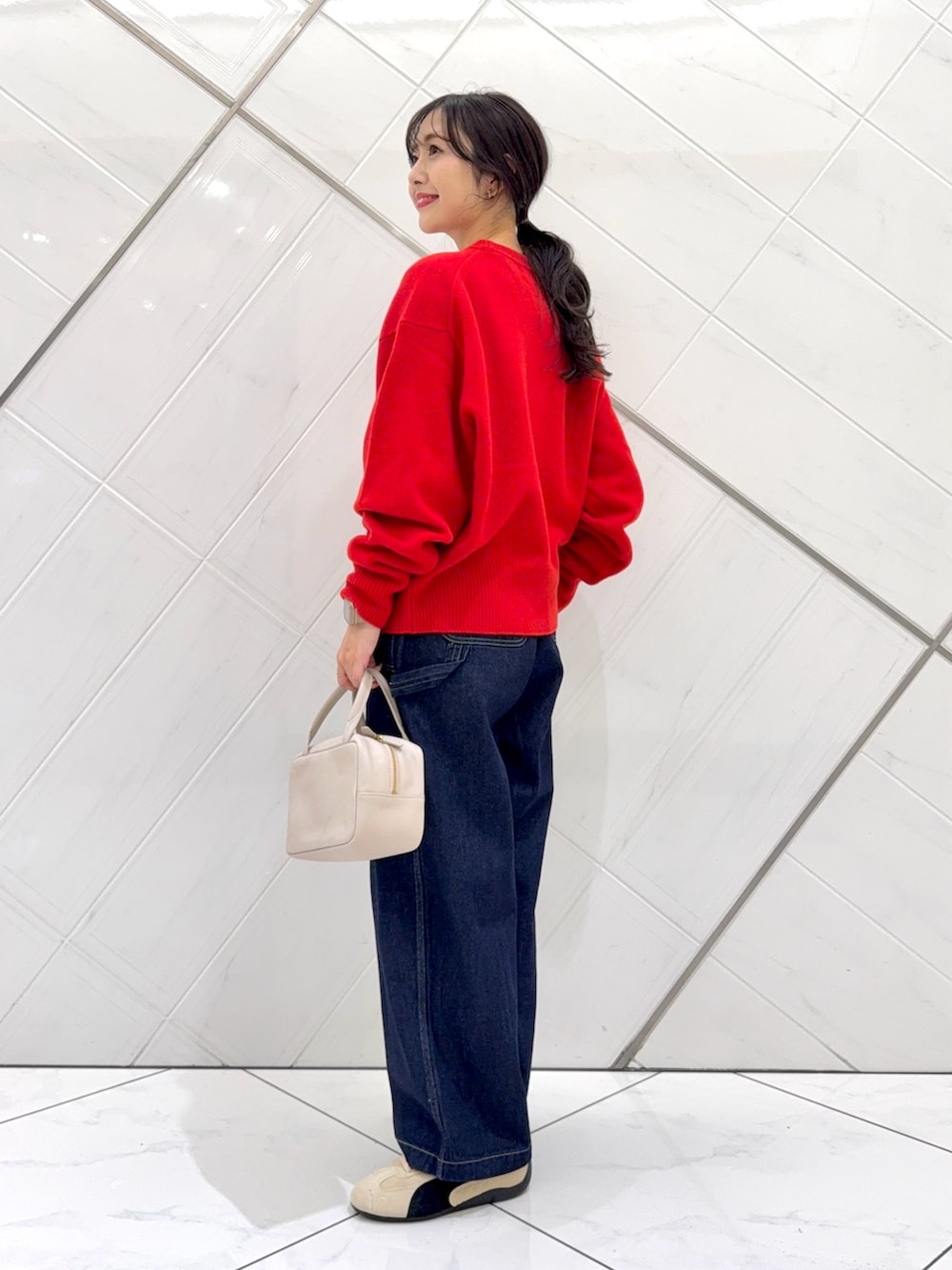 レッド系のニット/セーター、ホワイト系のTシャツ/カットソー、グレー系のボストンバッグを着用したレディースの秋コーディネートの7枚目の写真