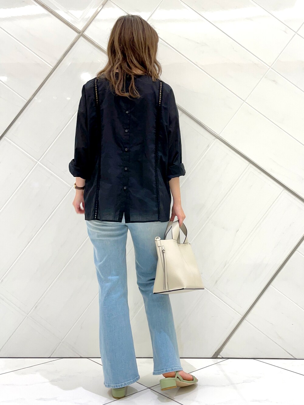 ブルー系のデニムパンツ、グリーン系のサンダル、ブラック系のTシャツ/カットソーを着用したレディースの夏コーディネートの5枚目の写真